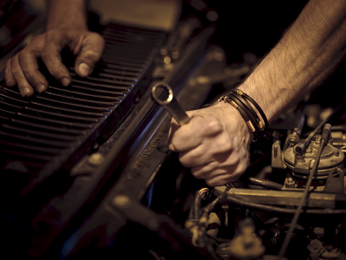 Hands working in a vehicle engine bay
